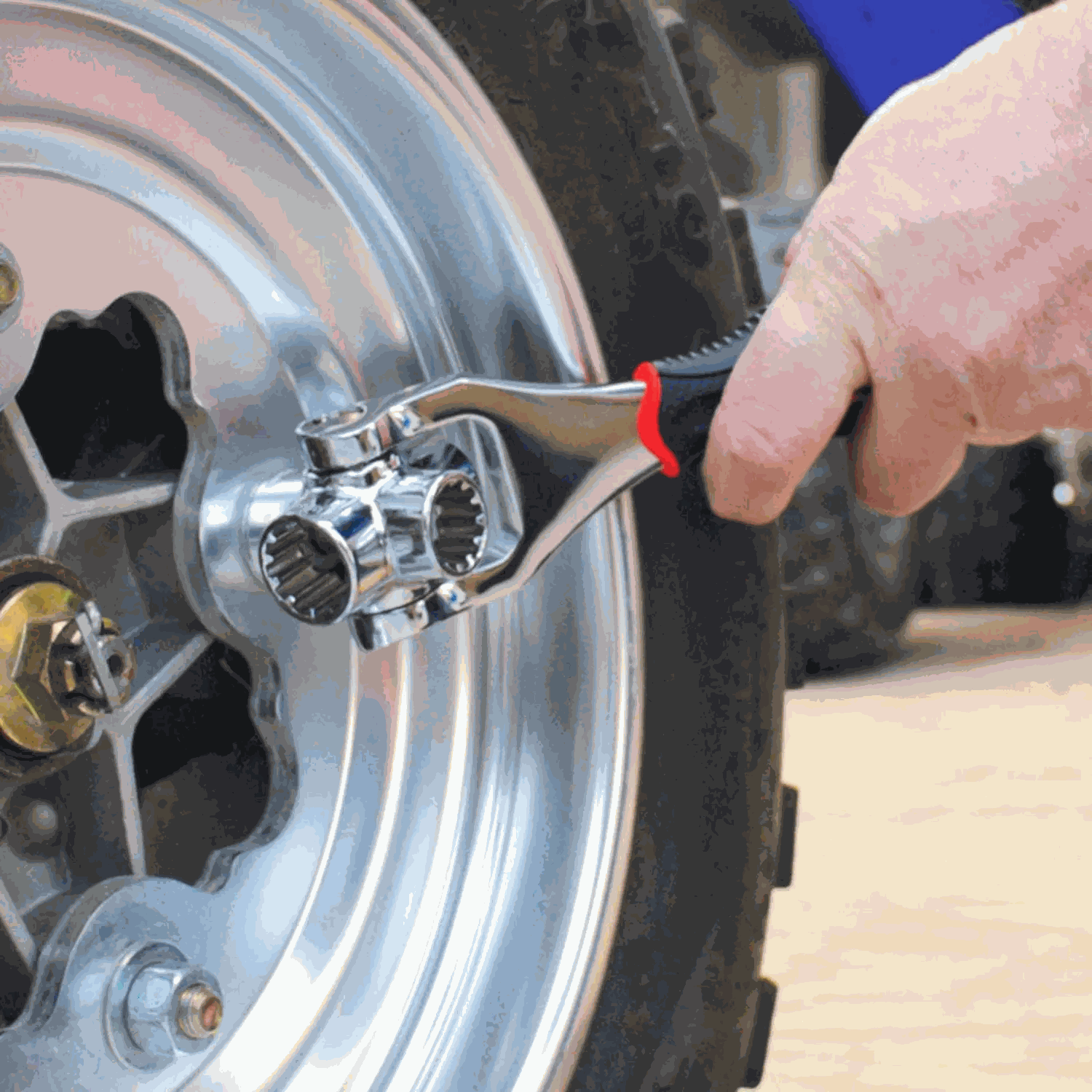 Hand using a tool to tighten bolts on a car wheel, showcasing car maintenance essentials from pkamazone.