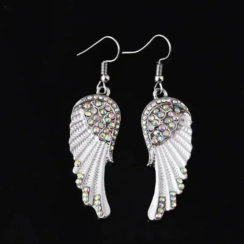 Angel wings silver-tone earrings with rhinestone accents on a black background.