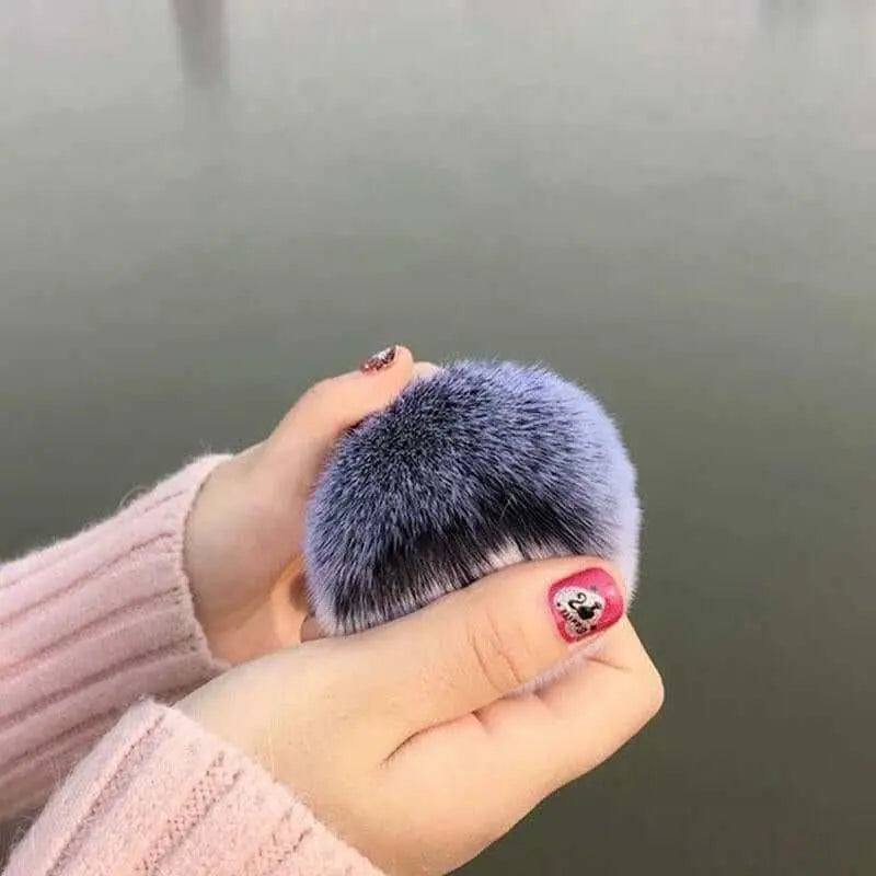 Soft chubby face makeup brush held in hands, ideal for seamless foundation application.