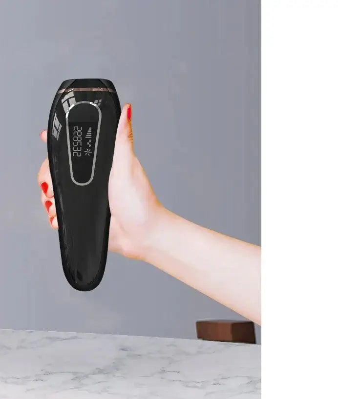 Hand holding a black home laser hair removal device, showcasing its sleek design and digital display.