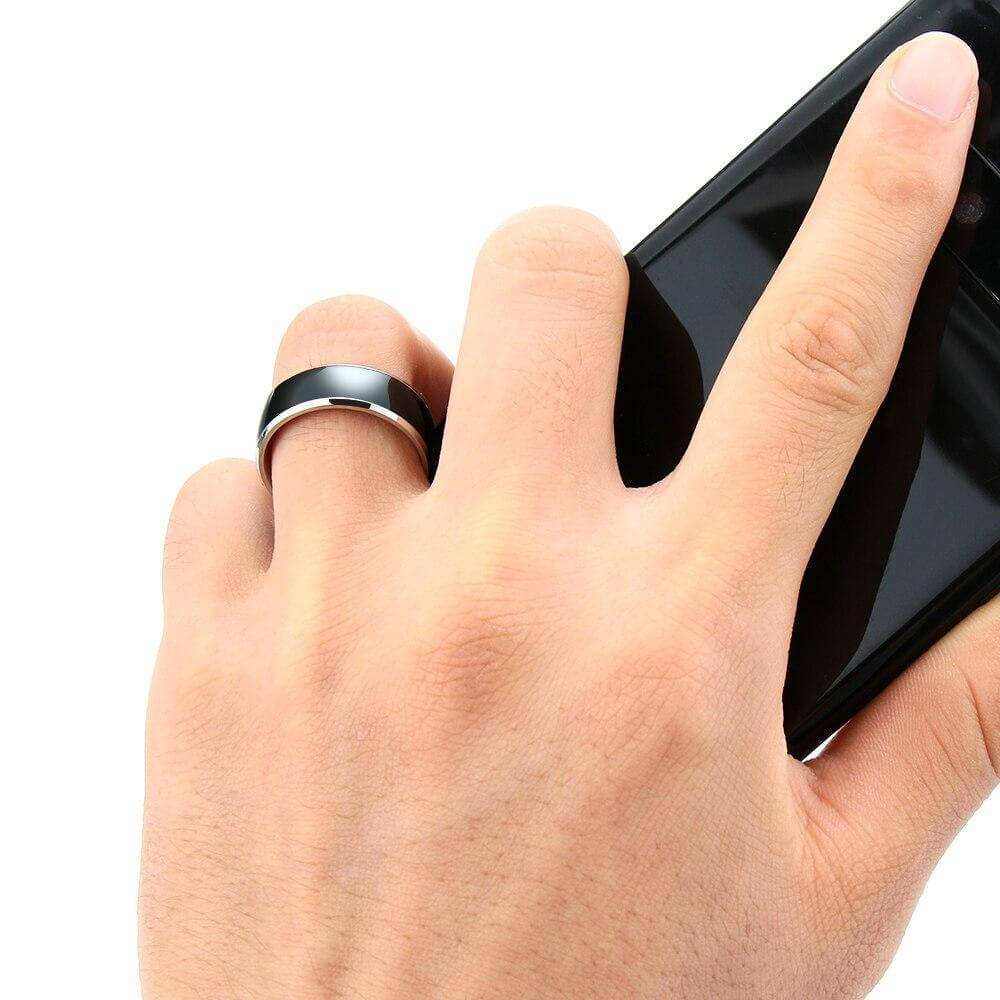 Intelligent multi-functional NFC smart ring on hand interacting with smartphone.