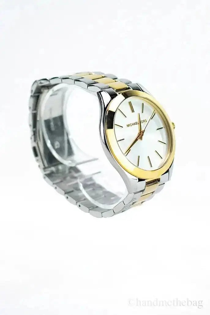 Michael Kors Slim Runway gold silver toned wrist watch with stainless steel band and stick indices.