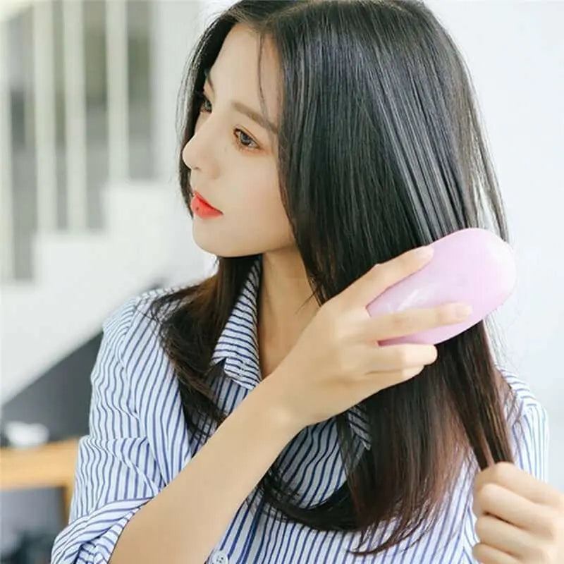 Woman using Portable Electric Ionic Styling Hairbrush for frizz-free hair.