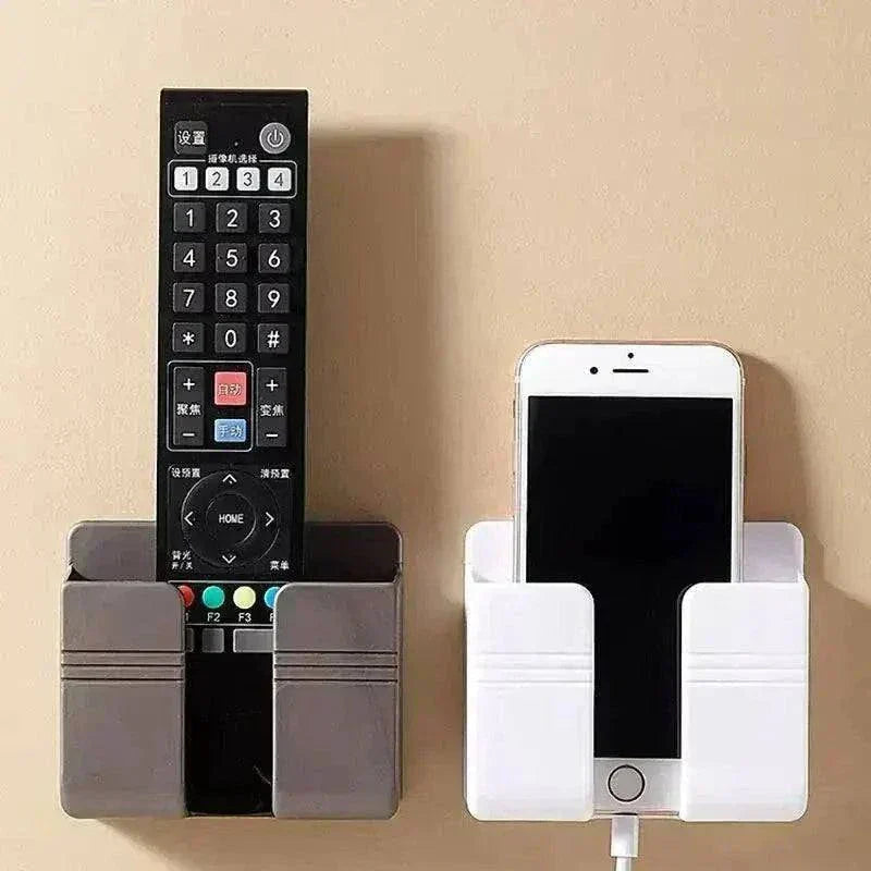Wall-mounted phone holder and remote organizer displaying a black remote and a white smartphone.
